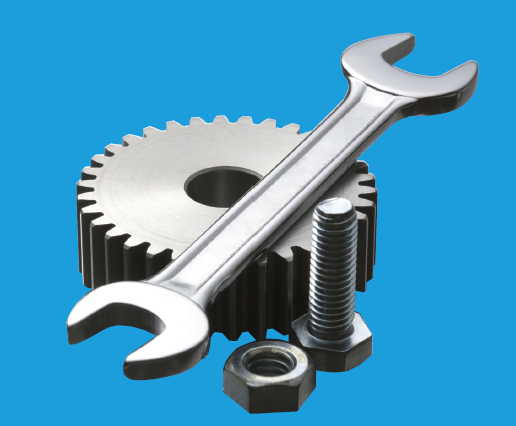 A photo of a gear, wrench, and nut and bolt set.