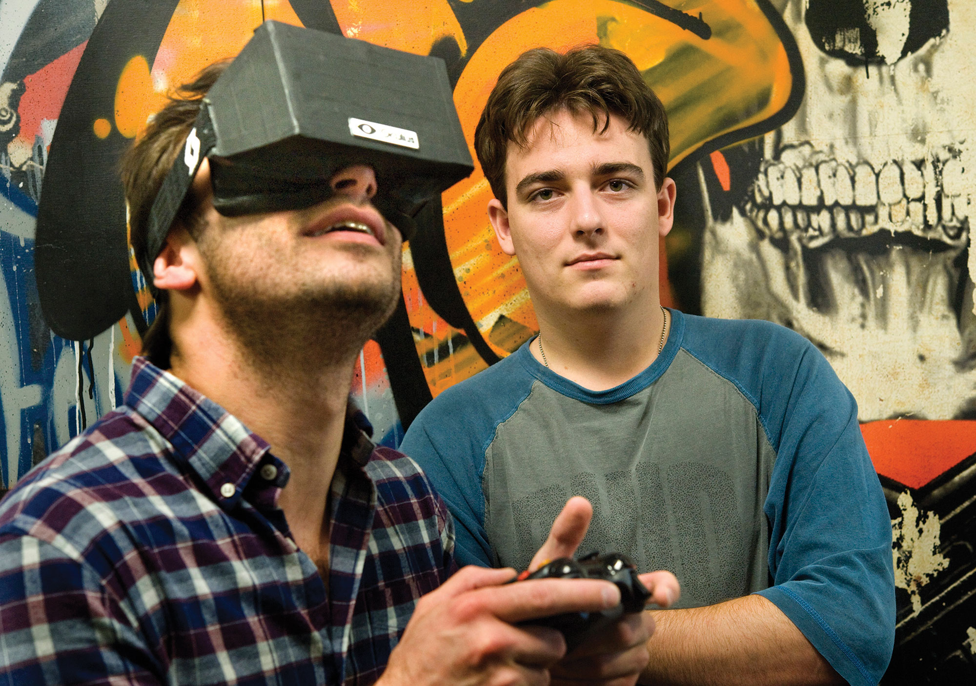 A photo shows Palmer Luckey standing with a man wearing VR headset.