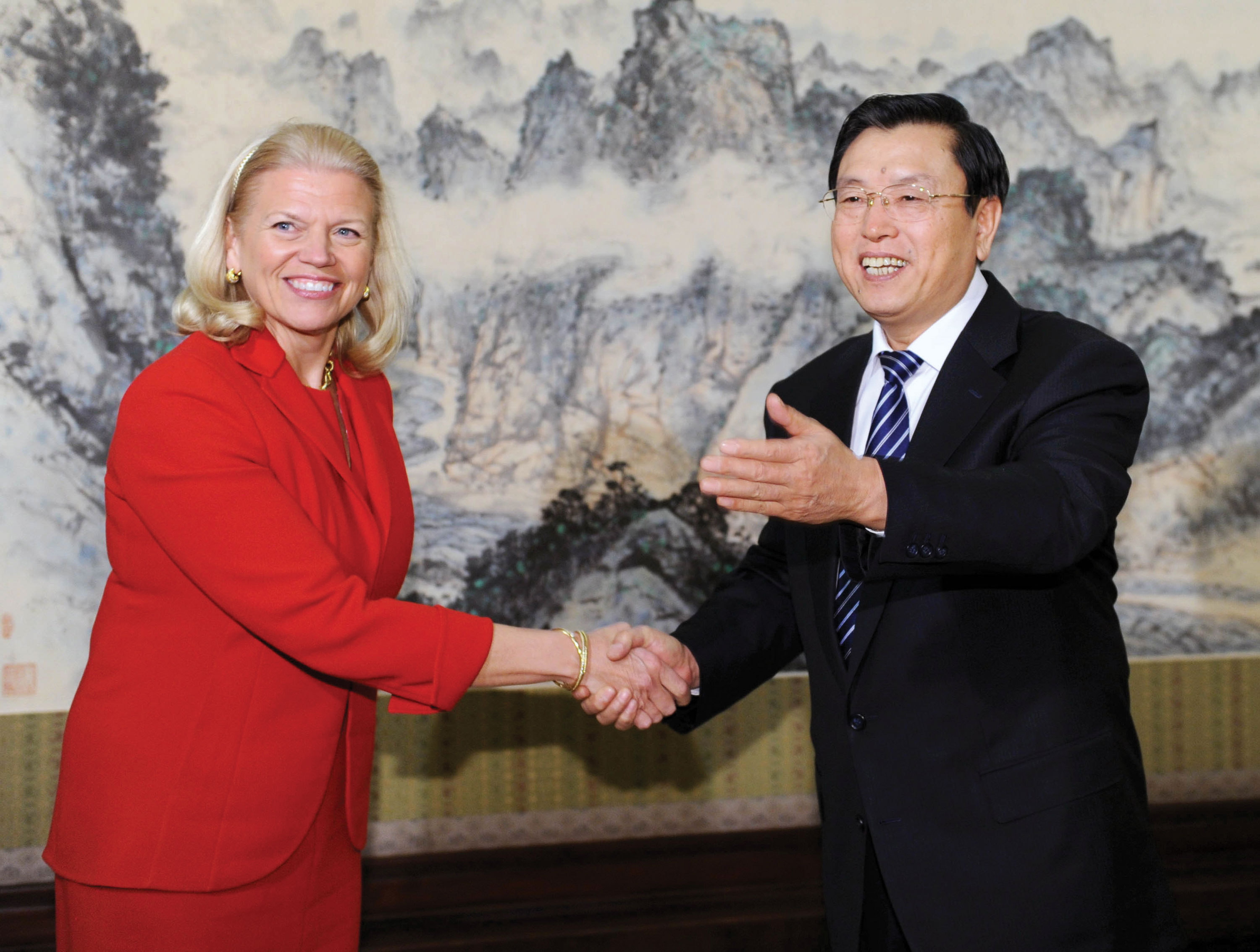 Photo of Virginia Rometty shaking hands with a man in Beijing while smiling