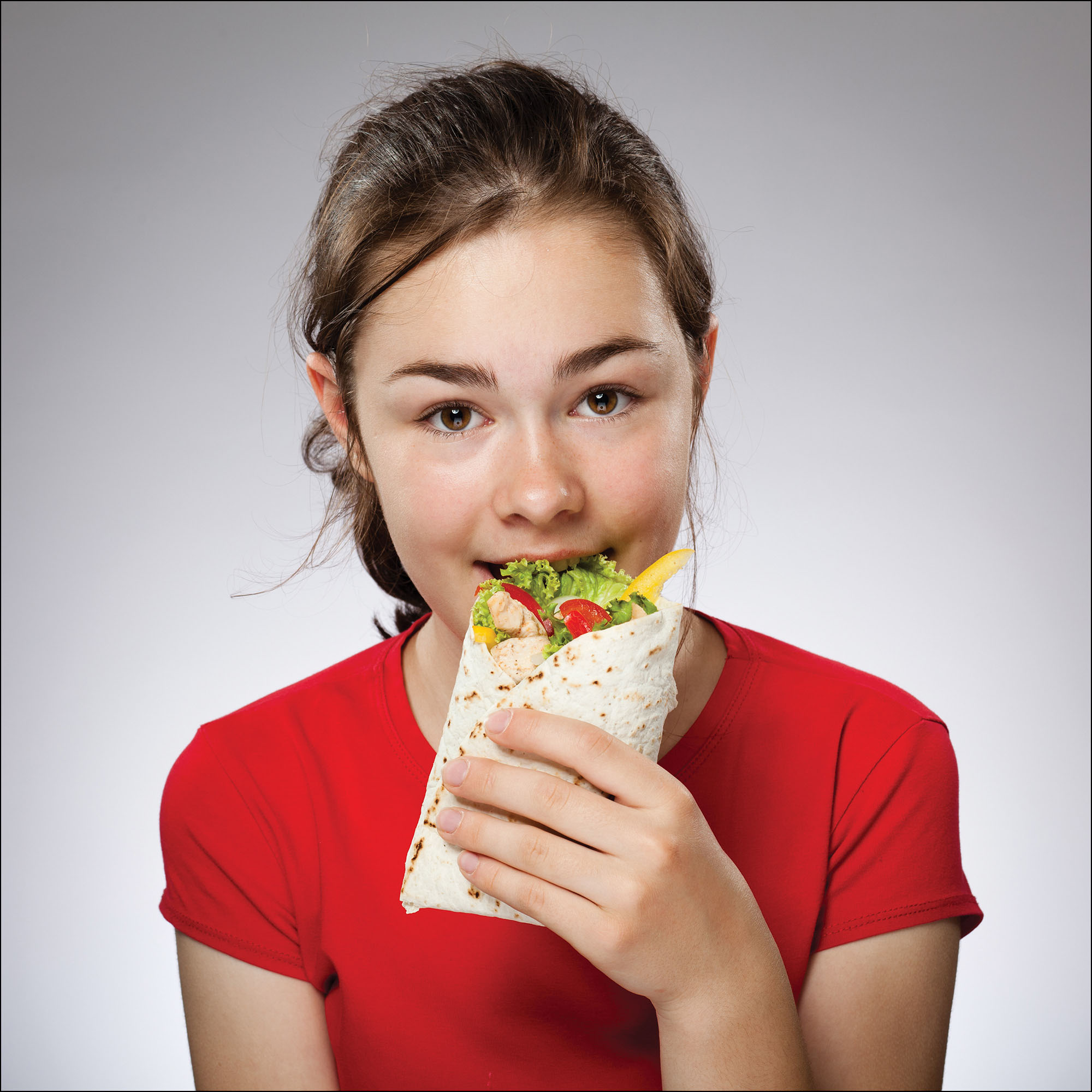 Photo of a girl eating a burrito