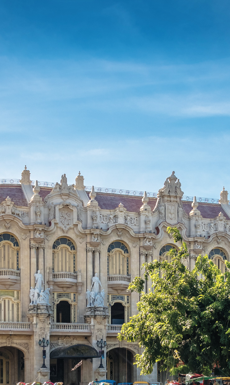 A photo shows the exterior architecture of Parque Central, Havana, Cuba. The richly decorated building is ornately decorted with many details.
