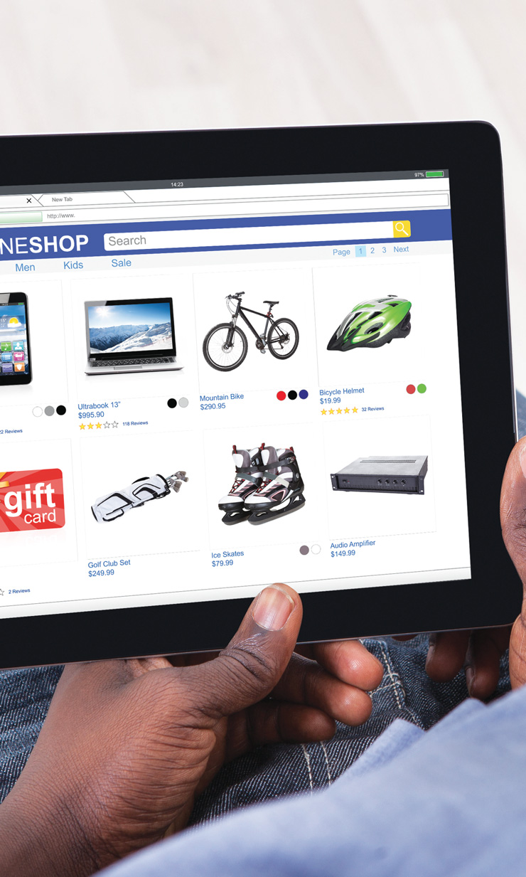 A photo of a man viewing products in an online shop on his tablet.