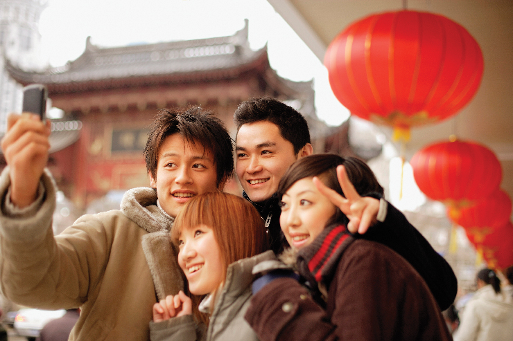 A photo of two young men and two young women standing close together for a selfie.