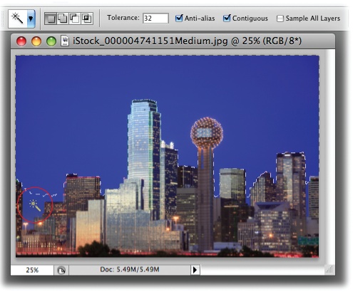 With its tolerance set to 32, the Magic Wand did a good job of selecting the sky behind downtown Dallas. You’ve got several ways to select the spots it missed like the area circled at the bottom left: You can add to the selection by pressing the Shift key as you click in that area, increase the tolerance setting in the Options bar and then click the sky again to create a new selection, or skip to to learn how to expand your selection with the Grow and Similar commands.