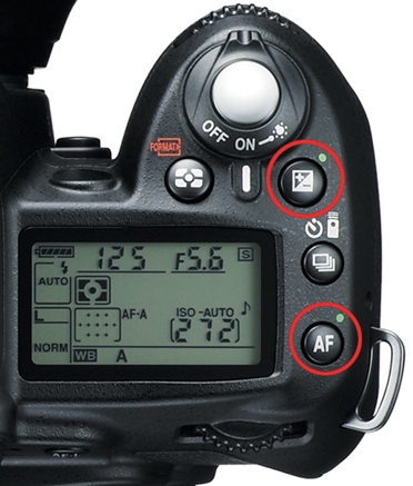 Press and hold the two circled buttons for two seconds to reset the camera to its factory defaults. Note that the two buttons each have a green dot next to them.