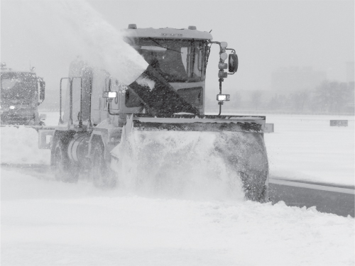 Photograph of a typical airport snow and ice control equipment (author in the center).