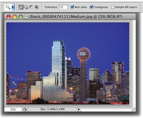 With its tolerance set to 32, the Magic Wand did a good job of selecting the sky behind downtown Dallas.You’ve got several ways to select the spots it missed like the area circled at the bottom left: You can add to the selection by pressing the Shift key as you click in that area, increase the tolerance setting in the Options bar and then click the sky again to create a new selection, or skip to page 154 to learn how to expand your selection with the Grow and Similar commands.