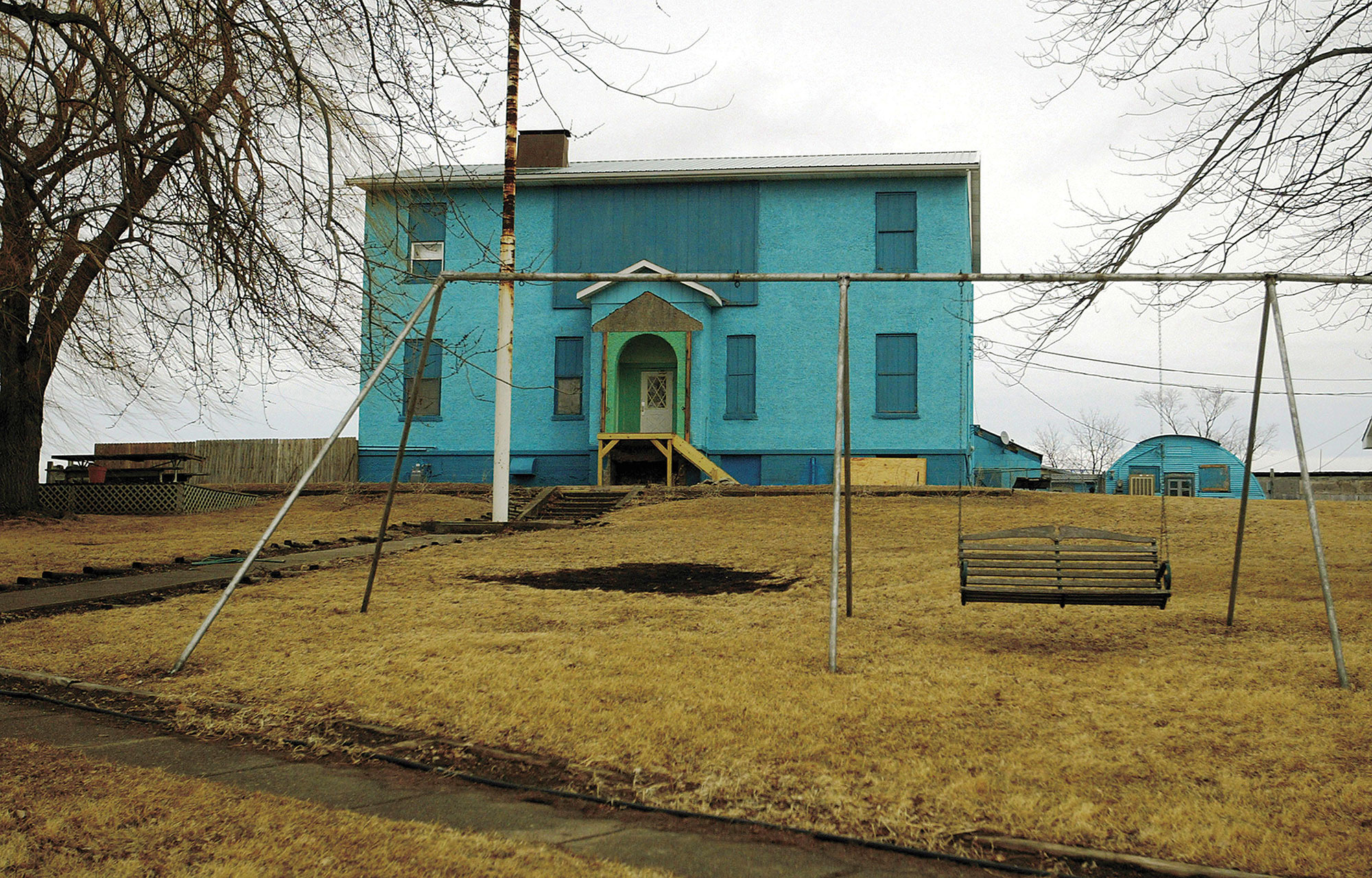 A photo shows a country house with a swing in the front.