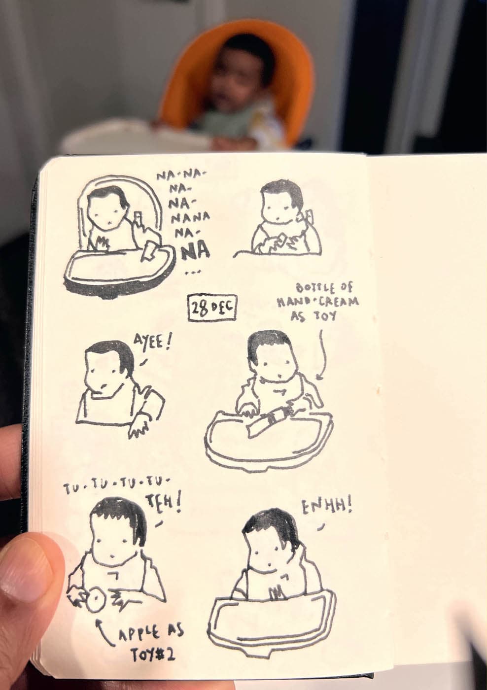 A hand-drawn comic of a baby in a high chair interacting with objects like a hand cream bottle and an apple, with humorous expressions and sounds.