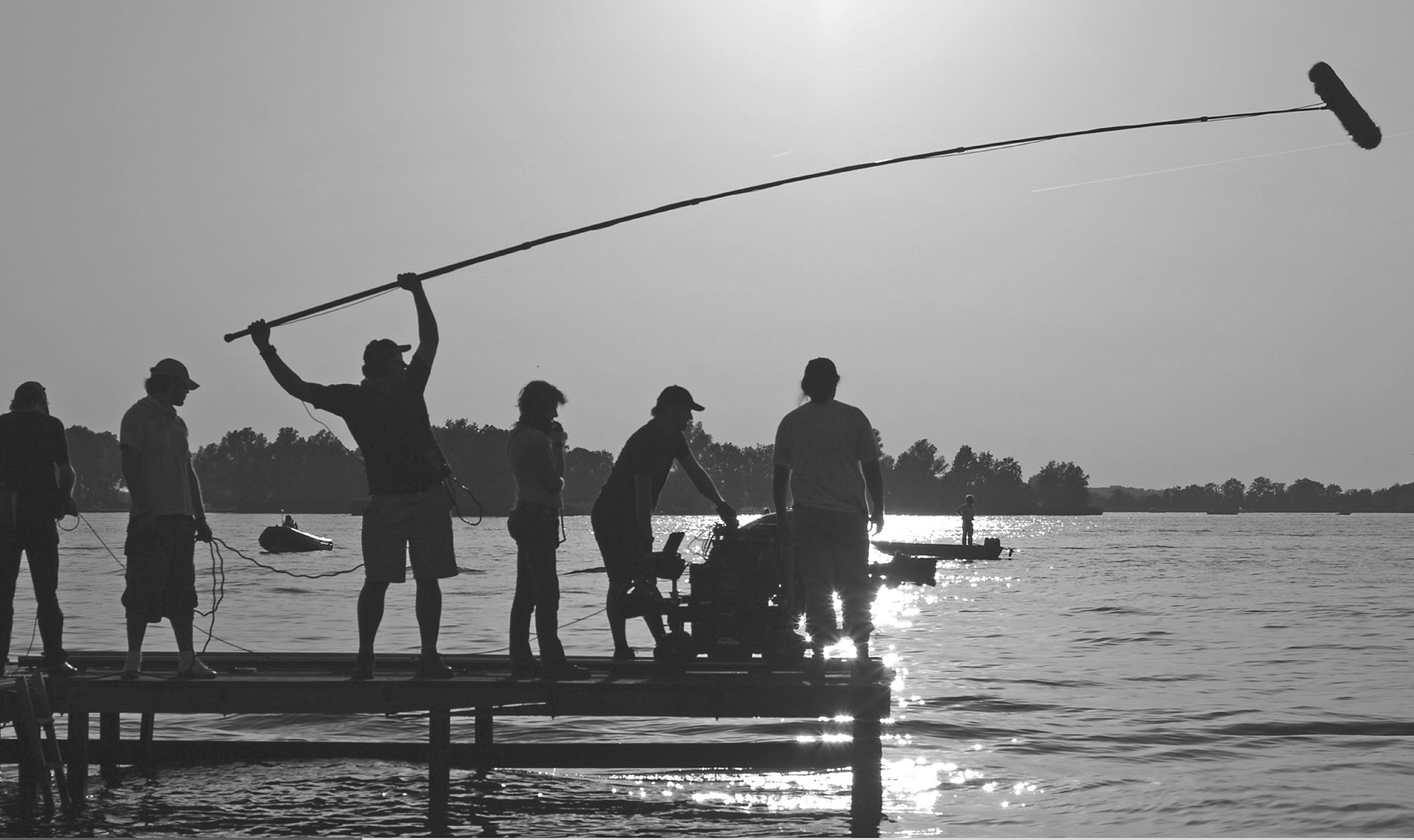 Two photos present film production scenes, depicting a crew filming on a dock at sunset, while another scene depicts a rural set with lighting and a child actor.