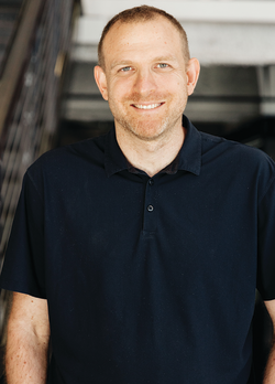 Photo of Assaf Keren, with short hair and a beard, smiling.