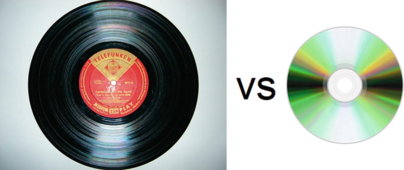 A photograph of a large circular dark-shaded vinyl record and a smaller shiny compact disc.