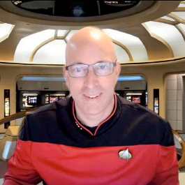 A person in front of a virtual Star Trek-themed background, reflecting themes of technology and innovation.