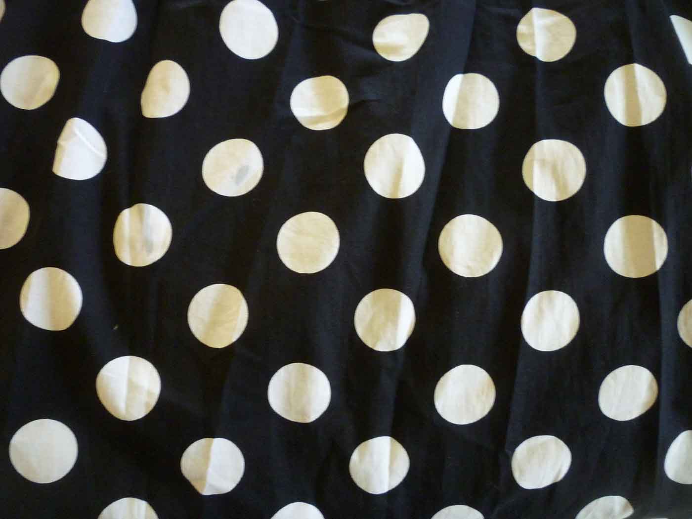 White polka dots on black cotton fabric