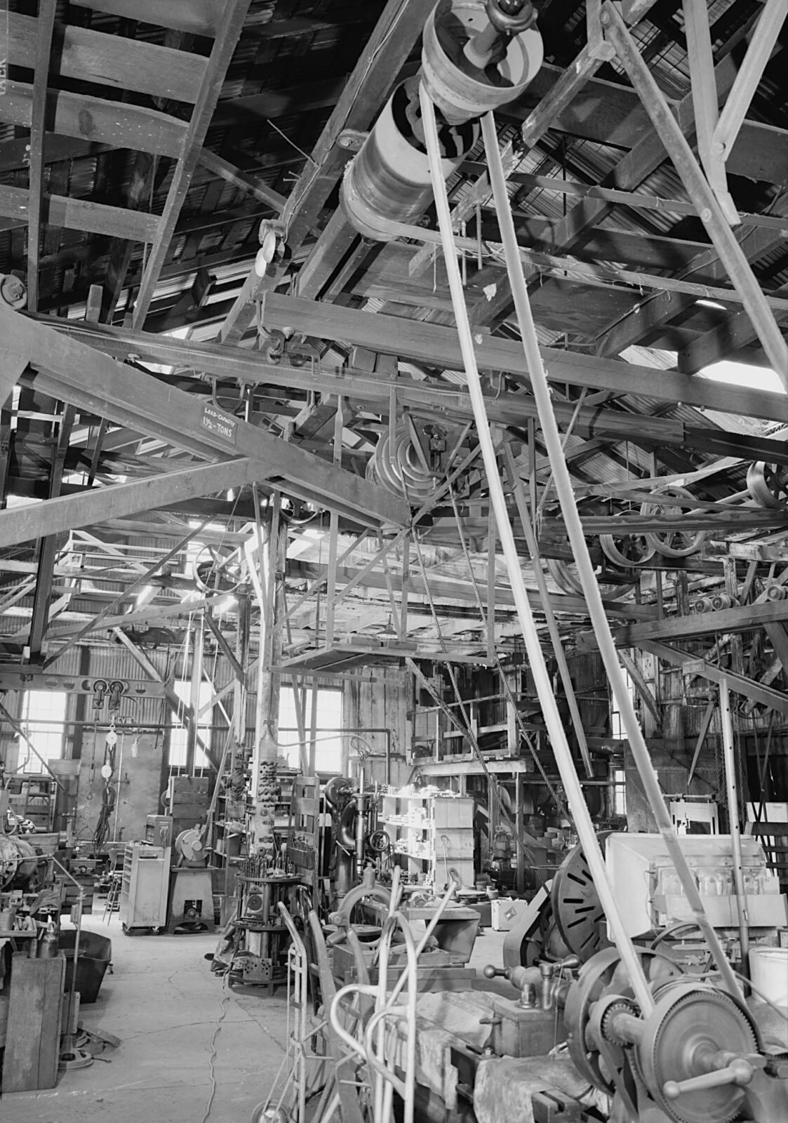MACHINE SHOP NORTH/NORTHEAST INCLUDING OVERHEAD LINE SHAFTING. MOSTLY BELT DRIVEN WITH ONE ROPE DRIVEN LATHE IN MIDDLE GROUND. POWER COMES FROM KNIGHT TURBINE ON FAR WALL. This image is available from the United States Library of Congress's Prints and Photographs division under the digital ID hhh.ca2269. Public Domain.