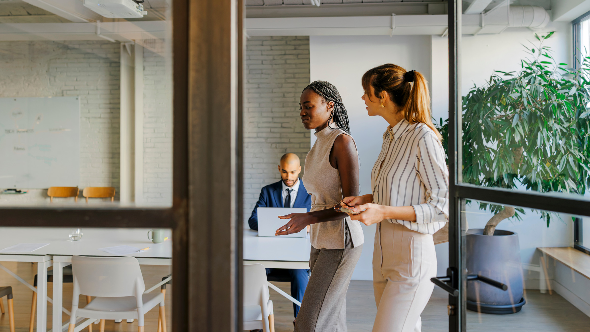 Businesswomen walking through office discussing project